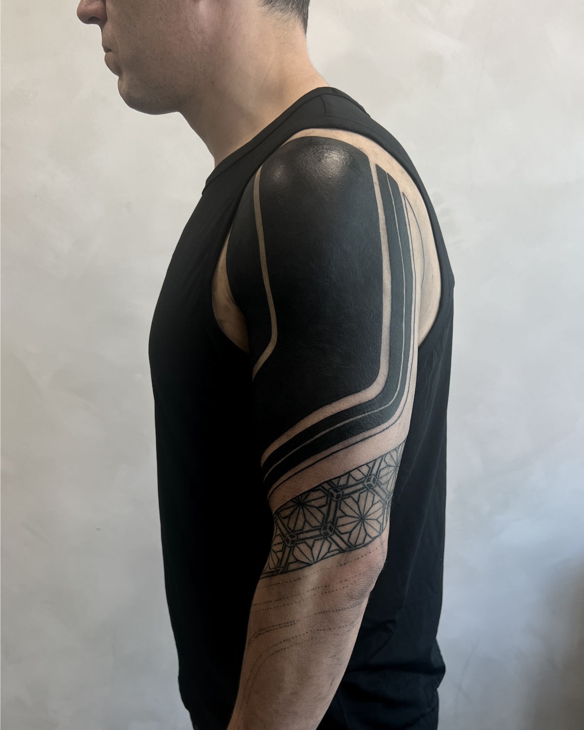 Blackout sleeve tattoo with negative space linework — James Nidecker Amsterdam